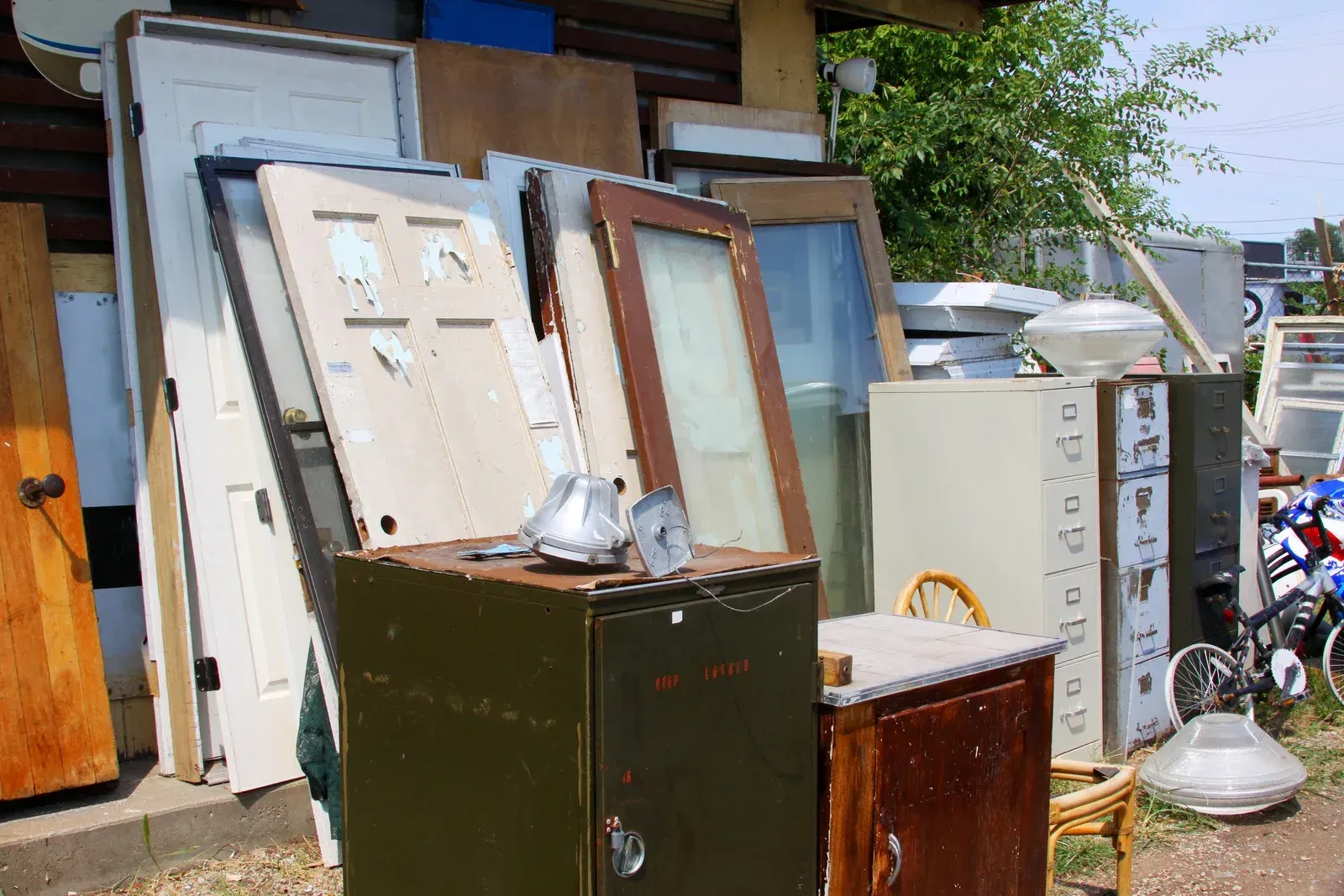 A pile of junk is sitting on the ground outside of a building.