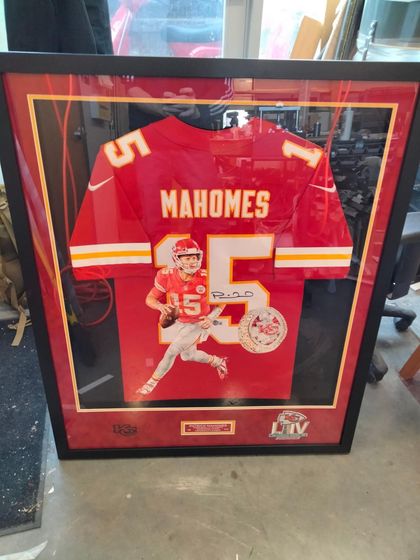 A framed, autographed Patrick Mahomes Kansas City Chiefs jersey featuring a Super Bowl LIV logo in a display case.