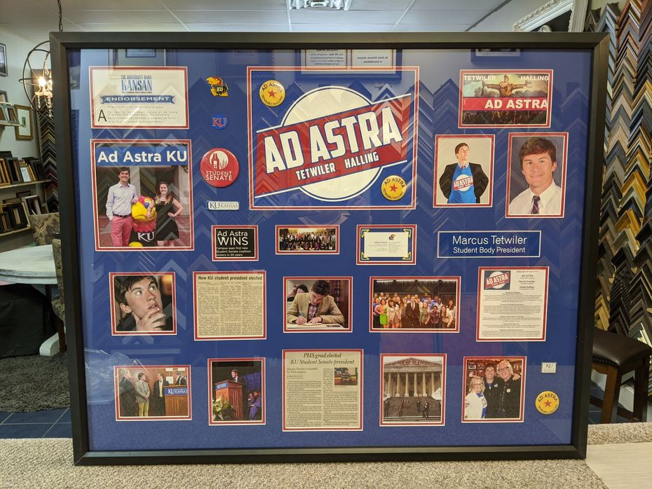A framed collage of photos, documents, and memorabilia celebrating the KU Ad Astra organization against a blue background.