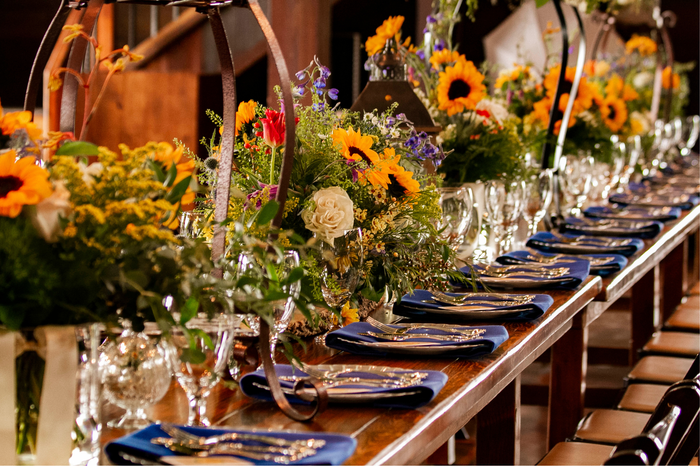 A long table with plates glasses and flowers on it