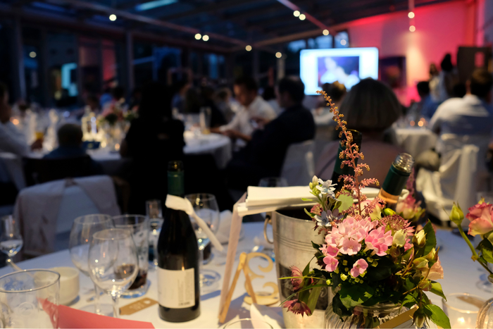 A bottle of wine is sitting on a table with flowers.