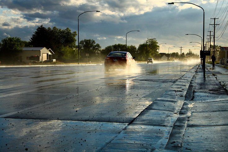 Car drives on wet asphalt.