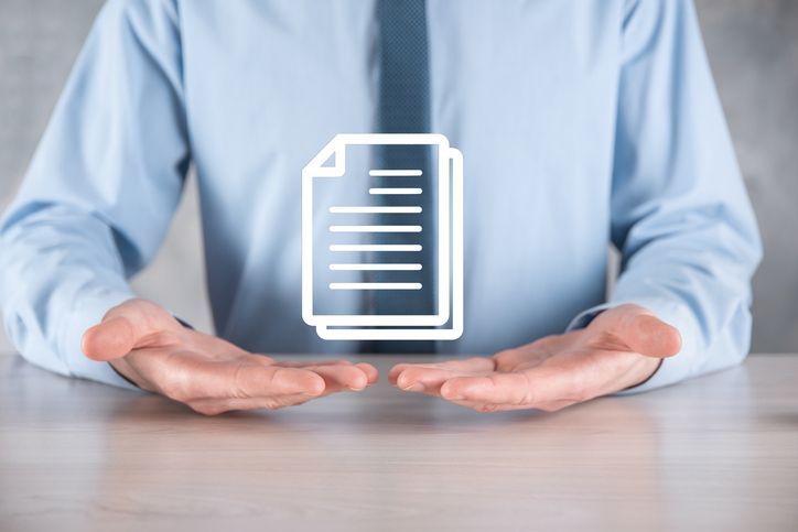 A man is holding a stack of papers in his hands.