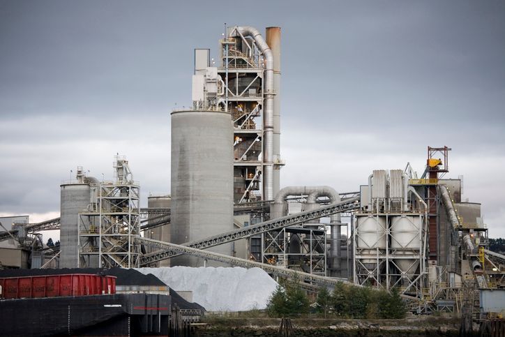 A large industrial plant with a cloudy sky in the background.