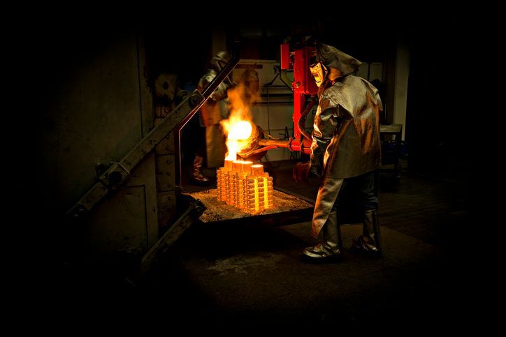 A man is working on a piece of metal in a factory.