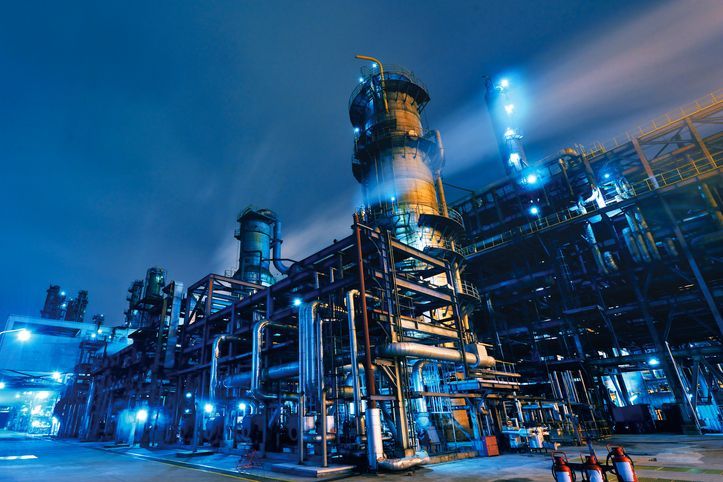 A large industrial plant is lit up at night.