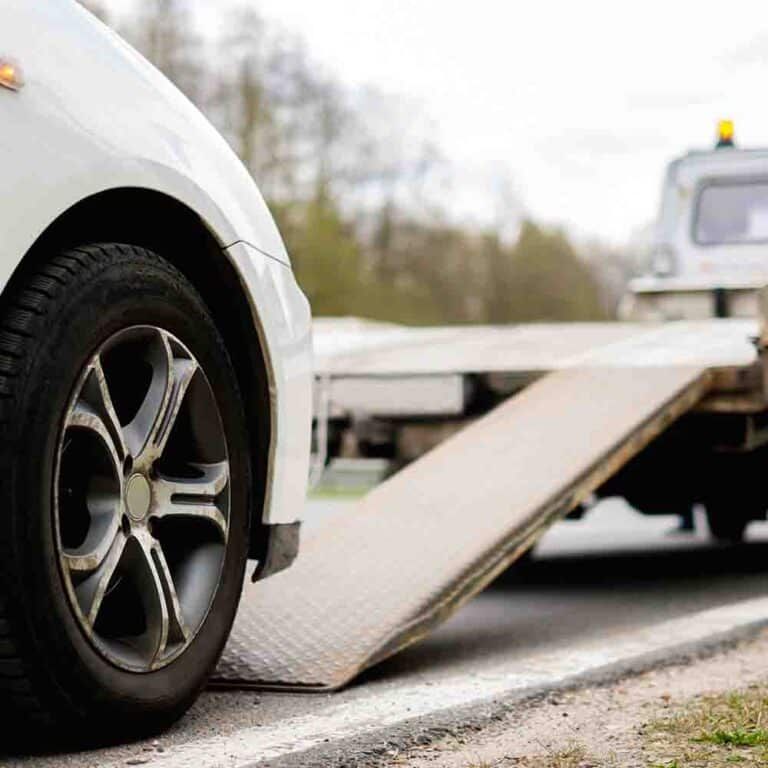 White Car Being Loaded Onto a Tow Truck, on the Side of a Road — Banjo's Anytime Towing in Humpty Doo, NT