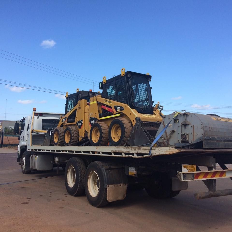 Yellow Construction Equipment Loaded on a Flatbed Truck Under a Blue Sky — Banjo's Anytime Towing in Humpty Doo, NT