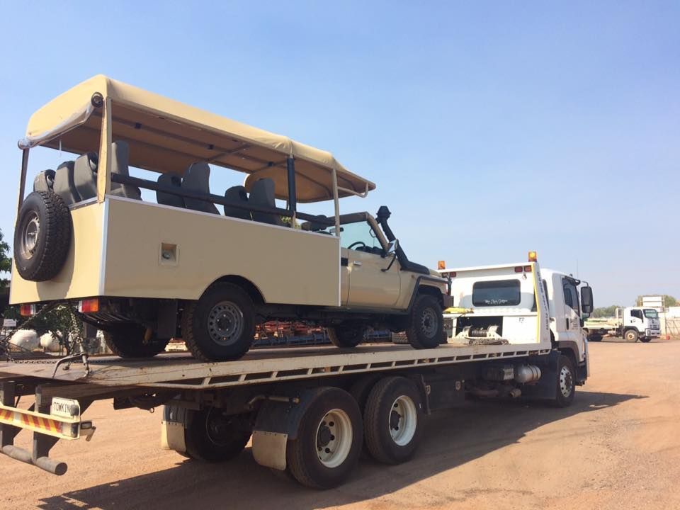 Beige safari vehicle on a flatbed truck in an outdoor setting under a clear sky — Banjo's Anytime Towing in Humpty Doo, NT