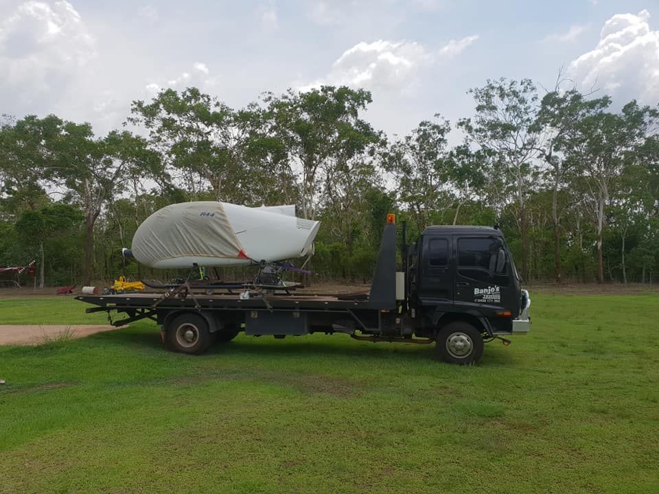 Black Tow Truck Carrying a Boat on Its Flatbed — Banjo's Anytime Towing in Darwin, NT