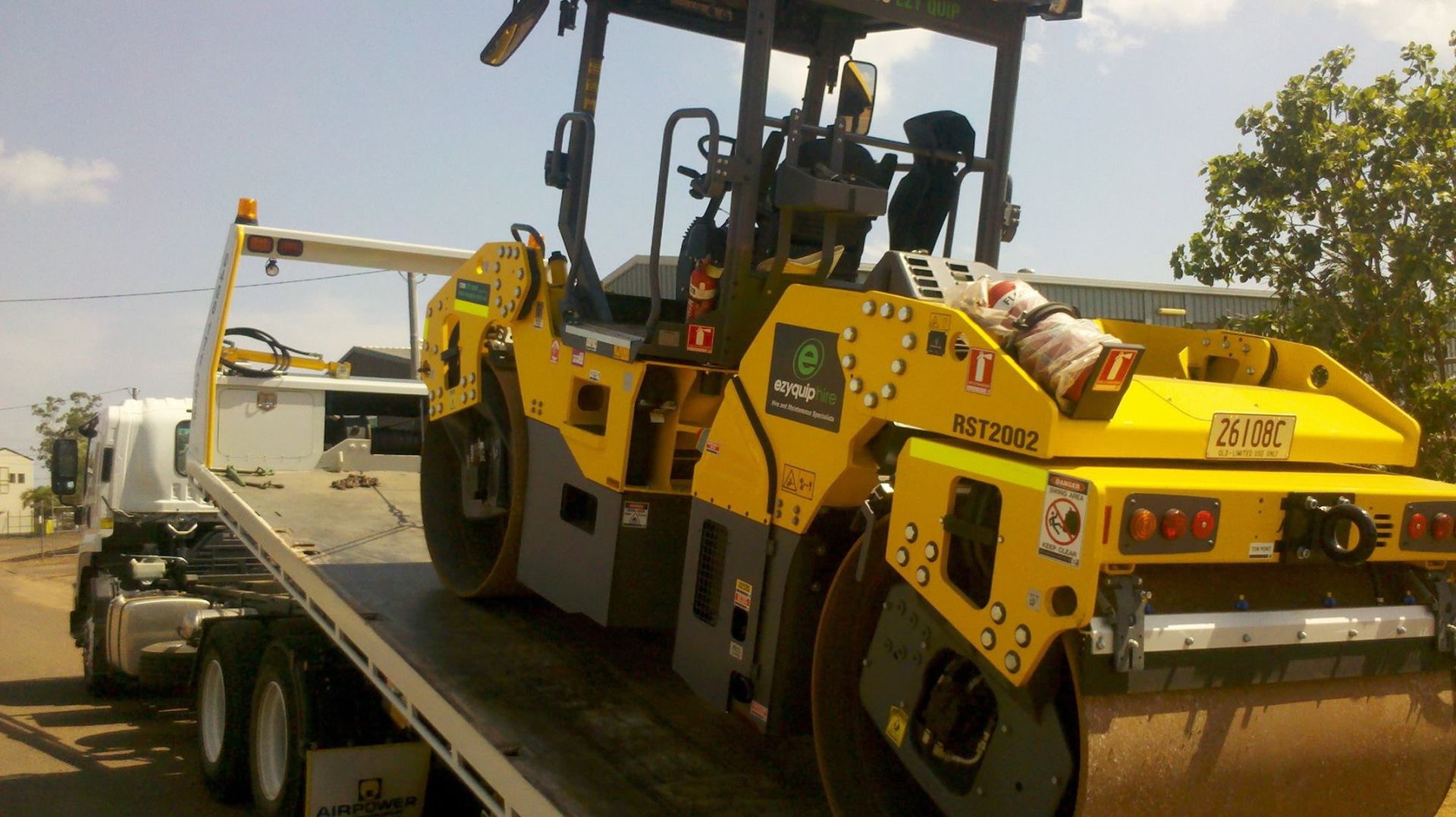 Yellow Road Roller on a Flatbed Truck — Banjo's Anytime Towing in Berrimah, NT