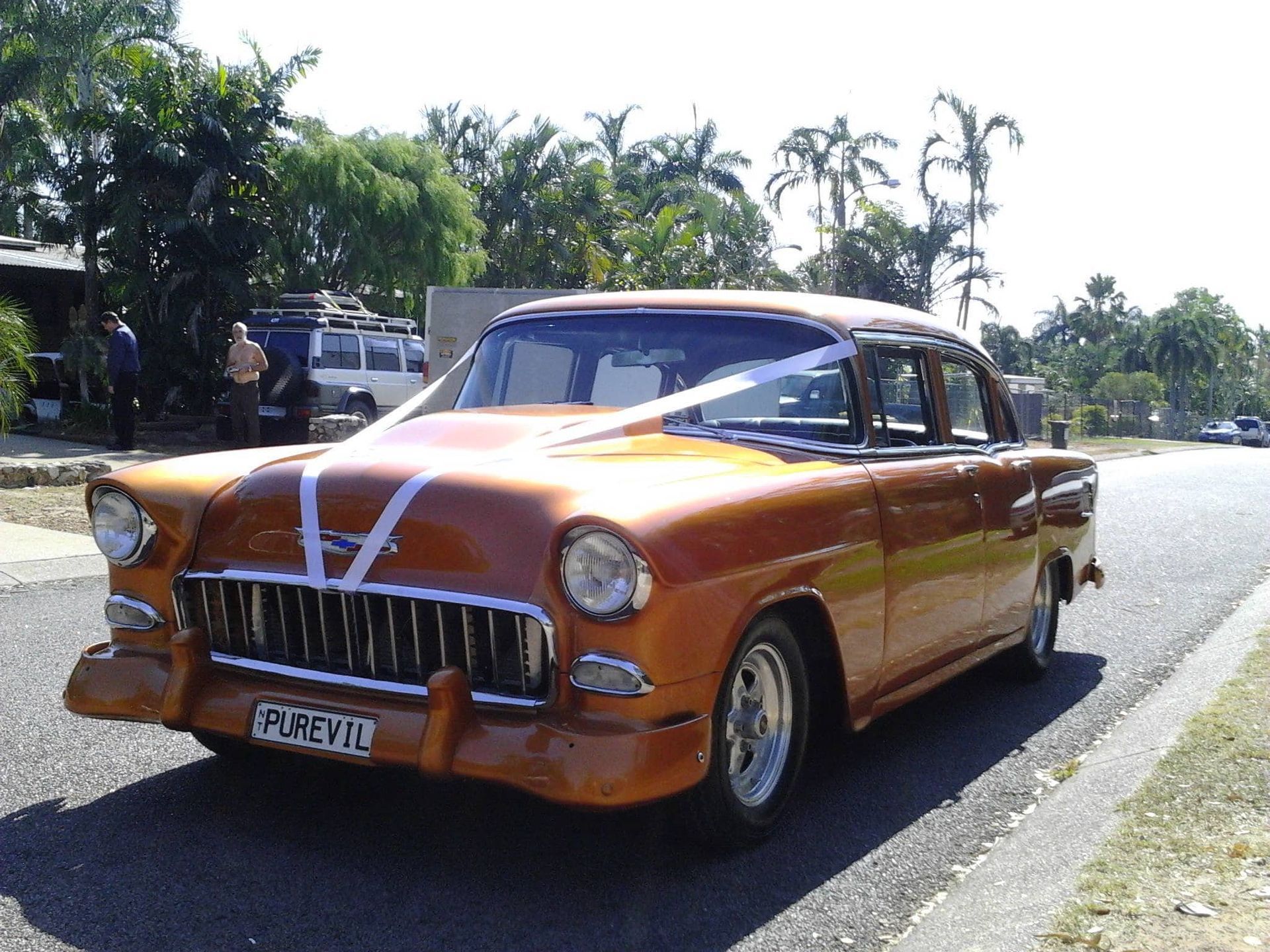 Orange Classic Car Decorated With Ribbons on a Sunny Street — Banjo's Anytime Towing in Winnellie, NT