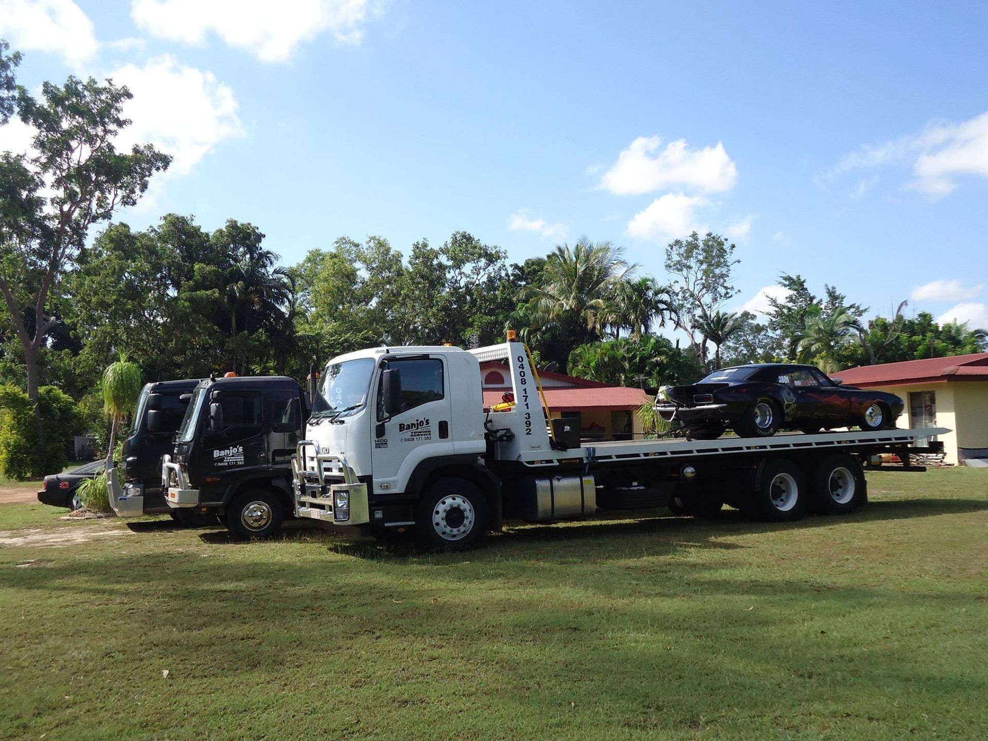 Tow Truck With a Black Car on the Flatbed — Banjo's Anytime Towing in Humpty Doo, NT