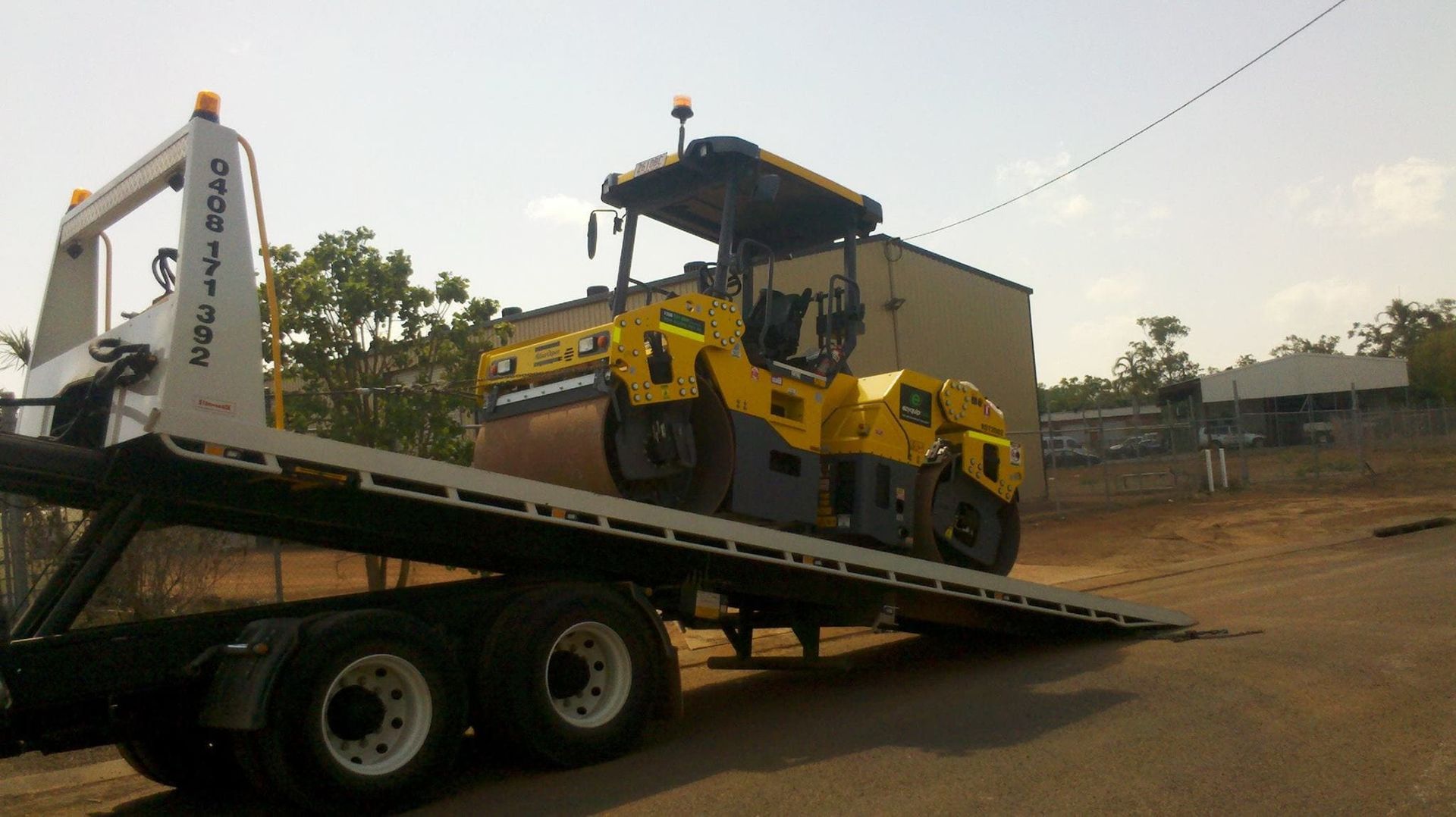 Yellow Road Roller on a Flatbed Truck, Likely for Transport — Banjo's Anytime Towing in Berrimah, NT
