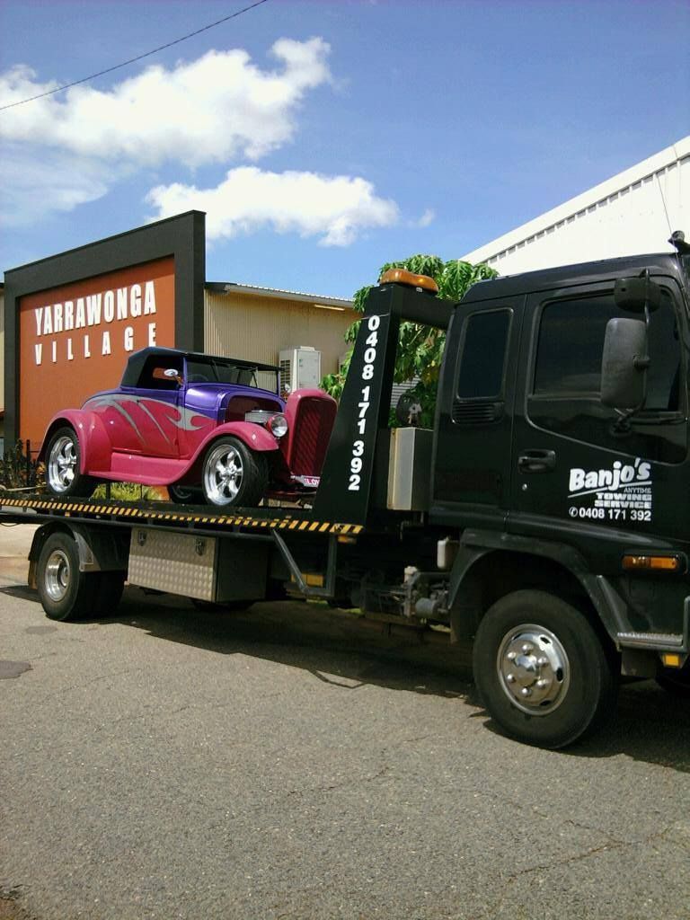 A Black Tow Truck Carrying a Purple and Red Hot Rod — Banjo's Anytime Towing in Humpty Doo, NT
