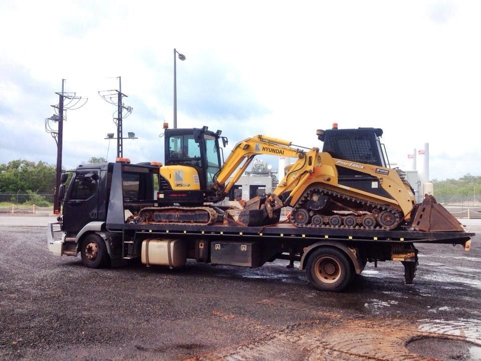 A Flatbed Truck With a Yellow Excavator and Skid Steer — Banjo's Anytime Towing in Howard Springs, NT