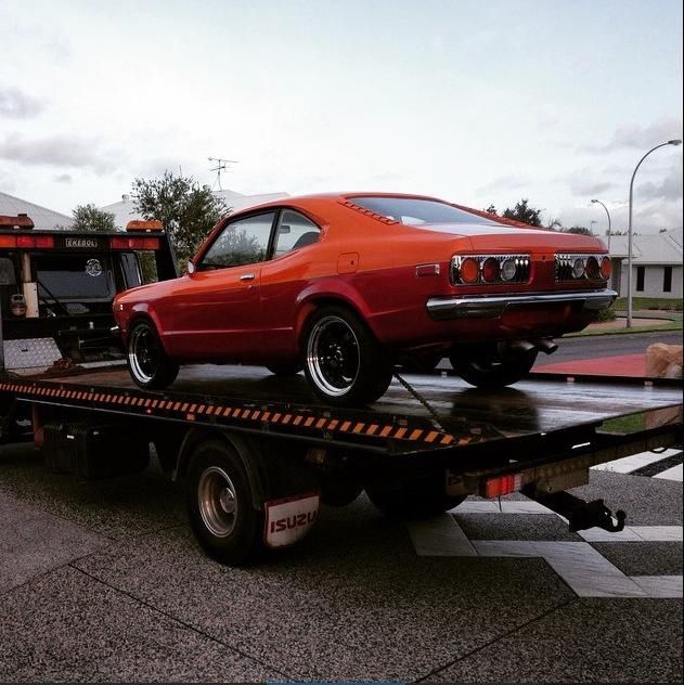 Orange Vintage Mazda Rx-3 on a Flatbed Tow Truck, on a Road — Banjo's Anytime Towing in East Arm, NT