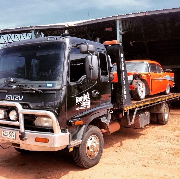 Black Tow Truck Carrying an Orange Classic Car. Outdoors, Sunny Day — Banjo's Anytime Towing in Winnellie, NT