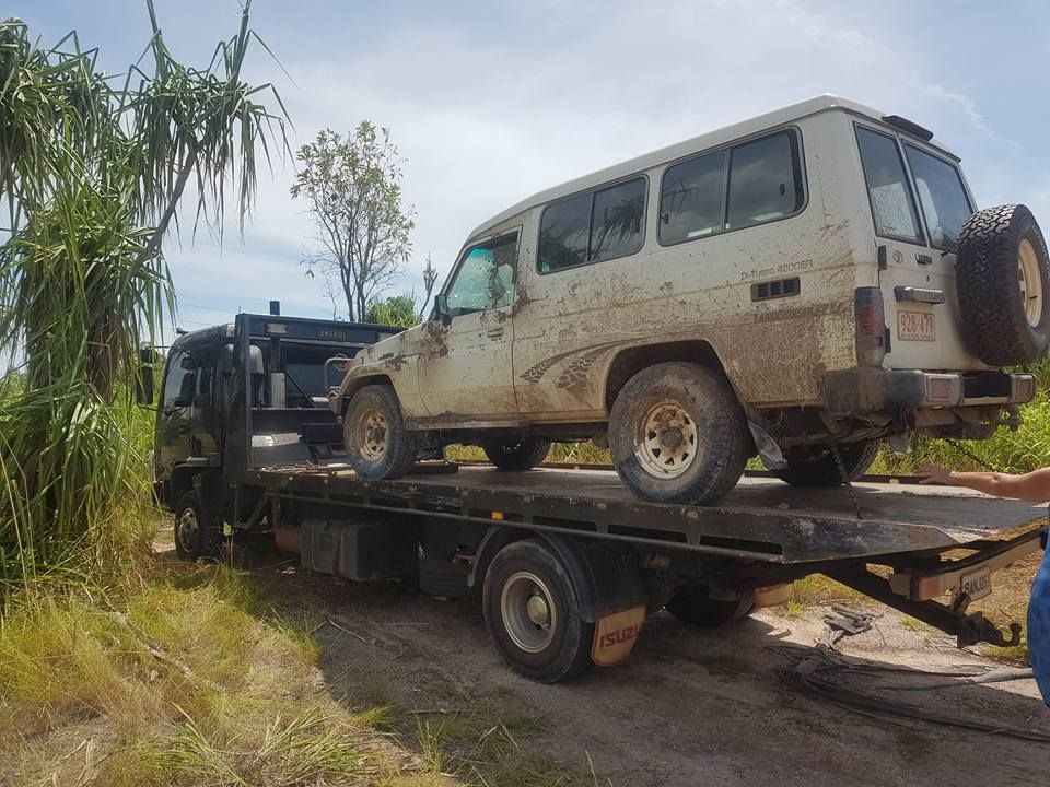 White, Muddy Suv on a Flatbed Tow Truck on a Dirt Road — Banjo's Anytime Towing in Humpty Doo, NT