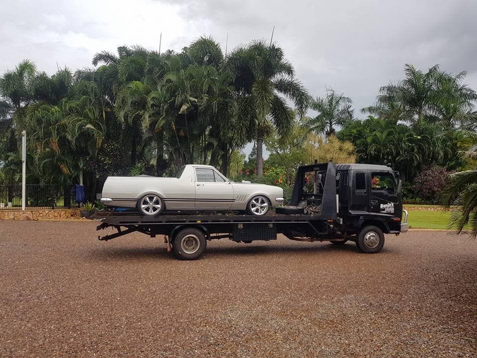 White car being loaded onto a tow truck on a roadside — Banjo's Anytime Towing in Humpty Doo, NT