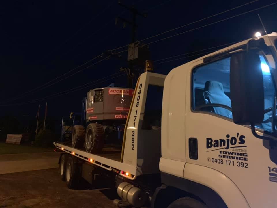 Tow Truck at Night Transports an Excavator — Banjo's Anytime Towing in Darwin, NT