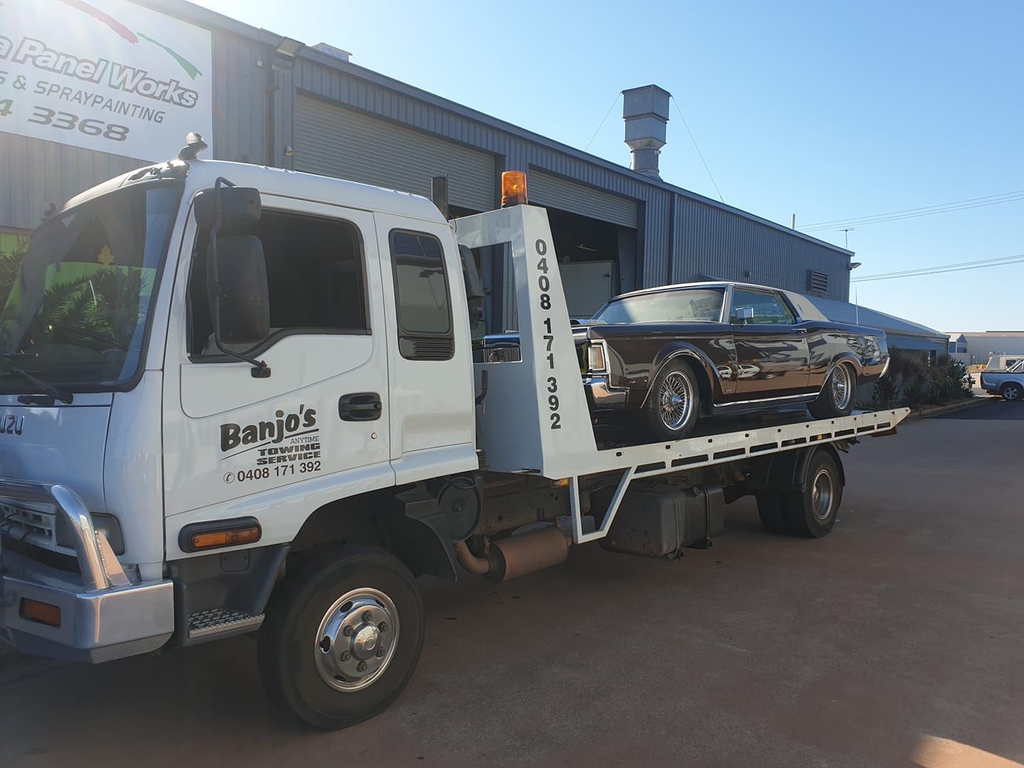 A Flatbed Tow Truck With Black Car