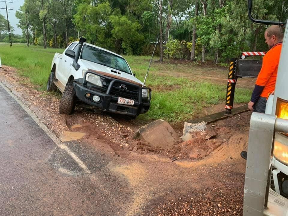 White truck stuck in muddy ditch beside a road — Banjo's Anytime Towing in Humpty Doo, NT