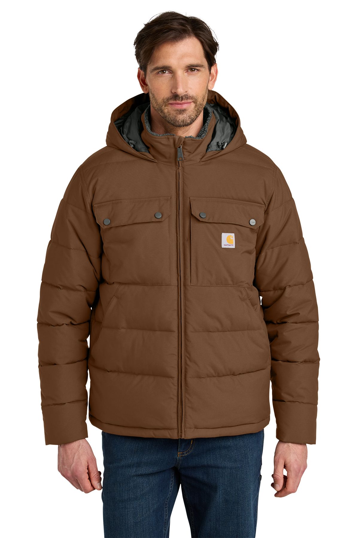 Man wearing a brown, hooded Carhartt puffer jacket, in front of a neutral backdrop.