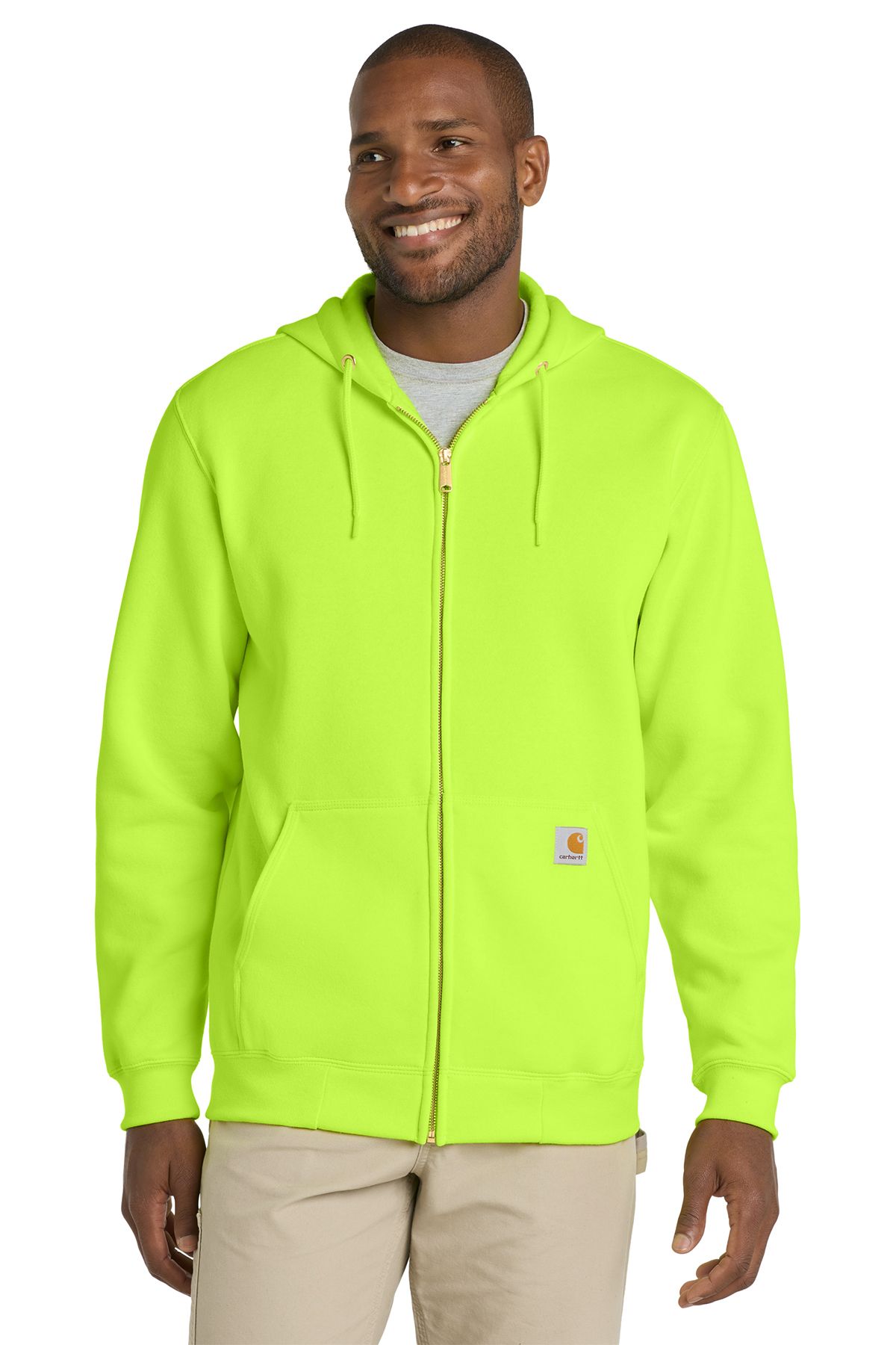 Man in neon yellow zip-up hoodie and khaki pants smiles.