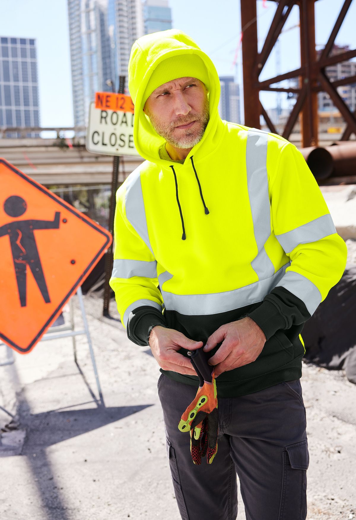 Man on a jobsite wearing a high visibility pullover hoodie