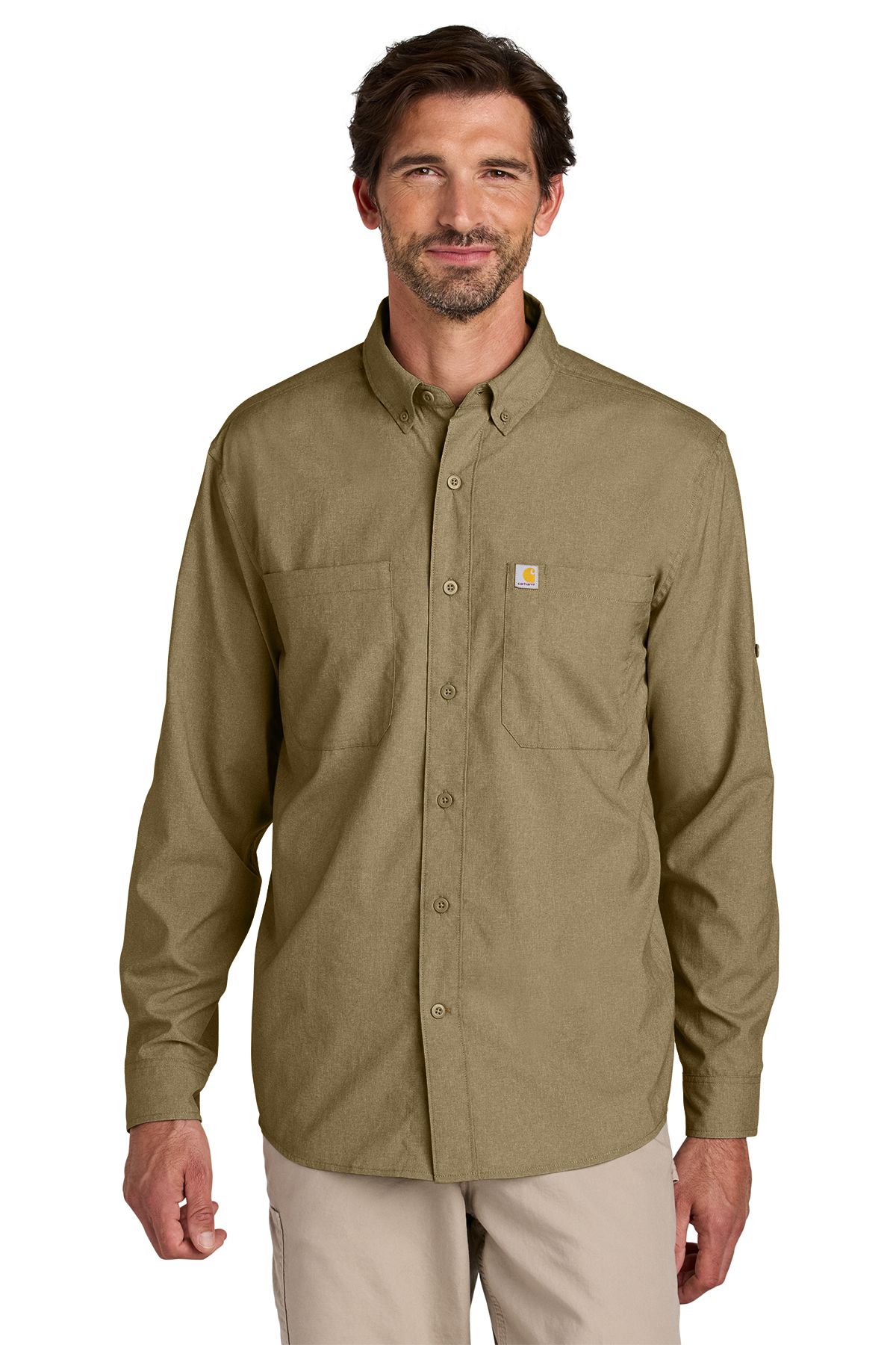 Man in olive green button-down shirt, tan pants, smiling, natural light.