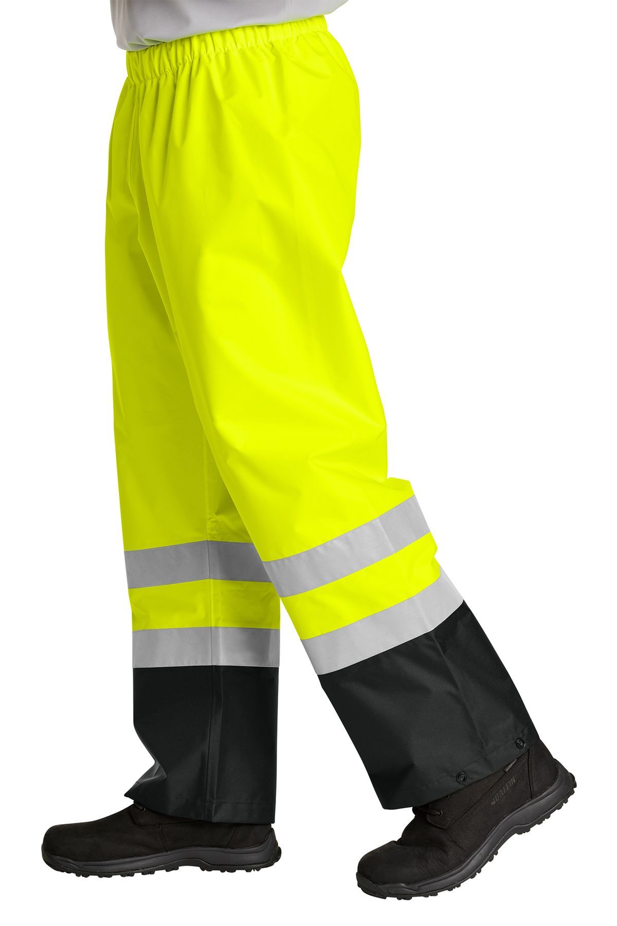 Person wearing bright yellow work pants with reflective stripes and black boots.