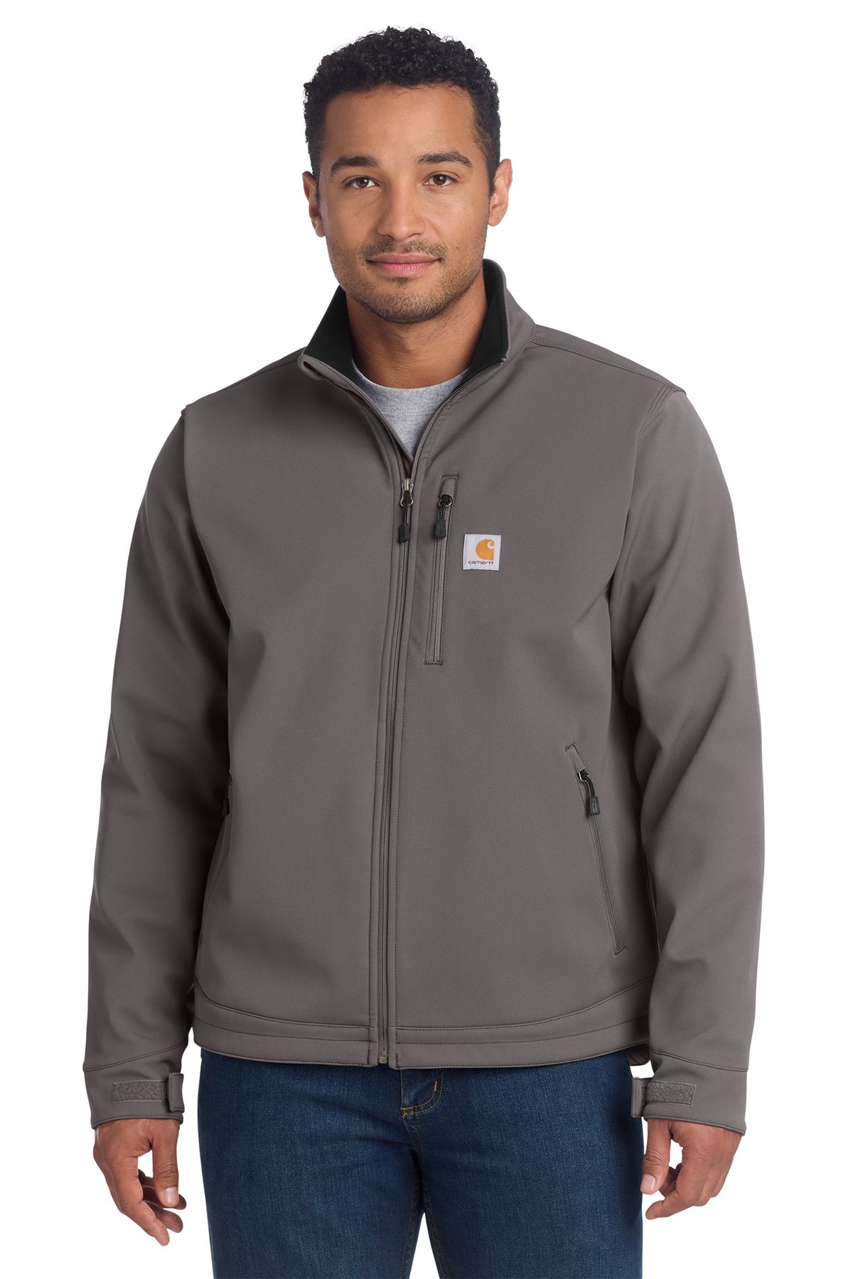 Man in gray Carhartt jacket, standing, full-zip. Black collar and pocket accents, jeans.