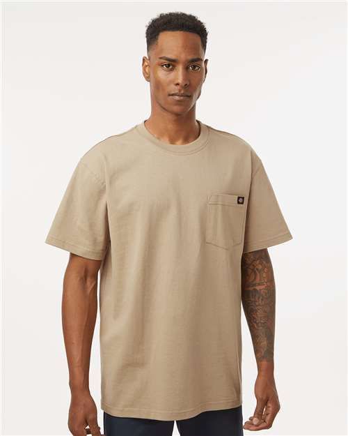 Man wearing a tan pocket t-shirt, standing and looking forward.