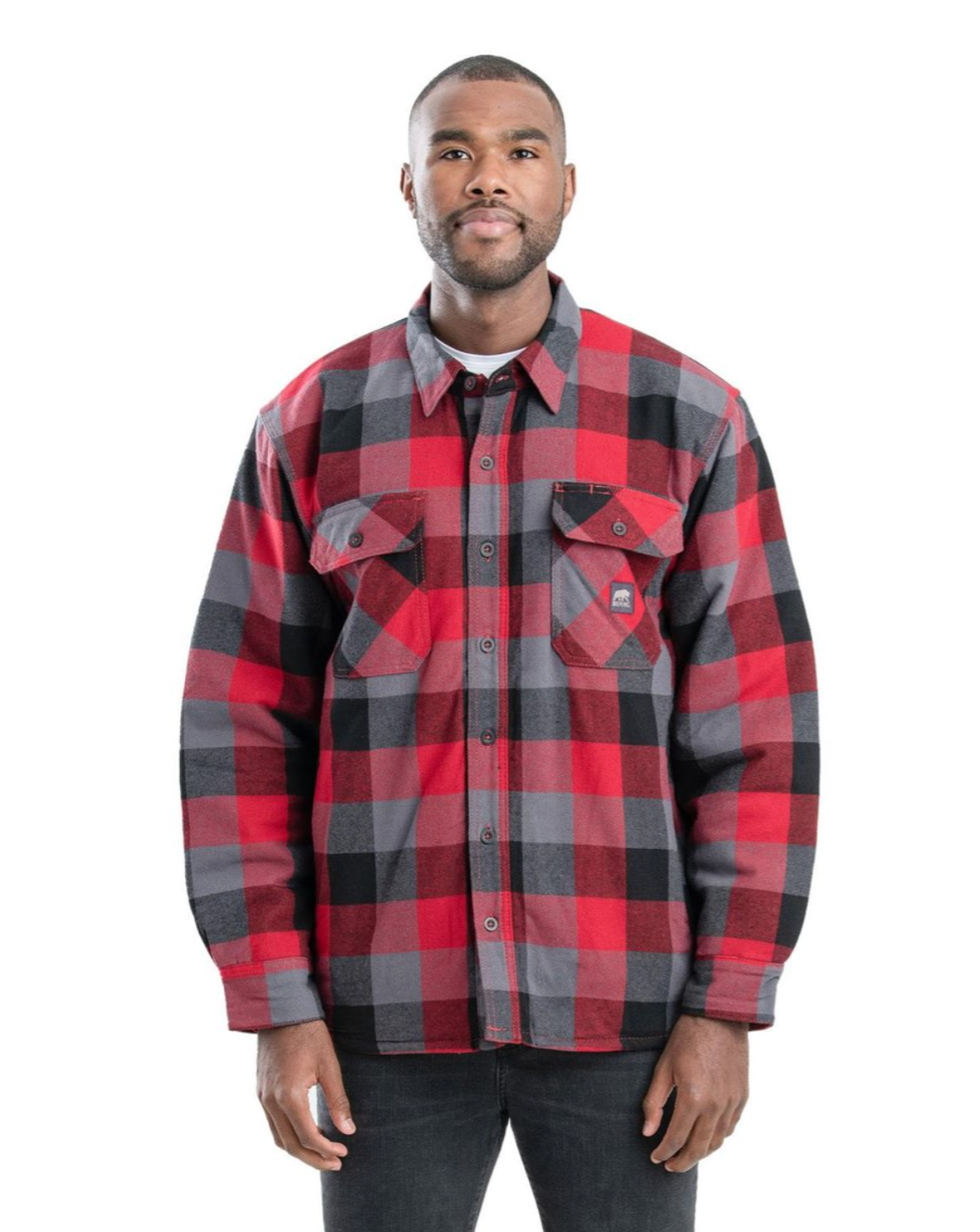 Man wearing red, black, and gray plaid flannel shirt, standing against white background.