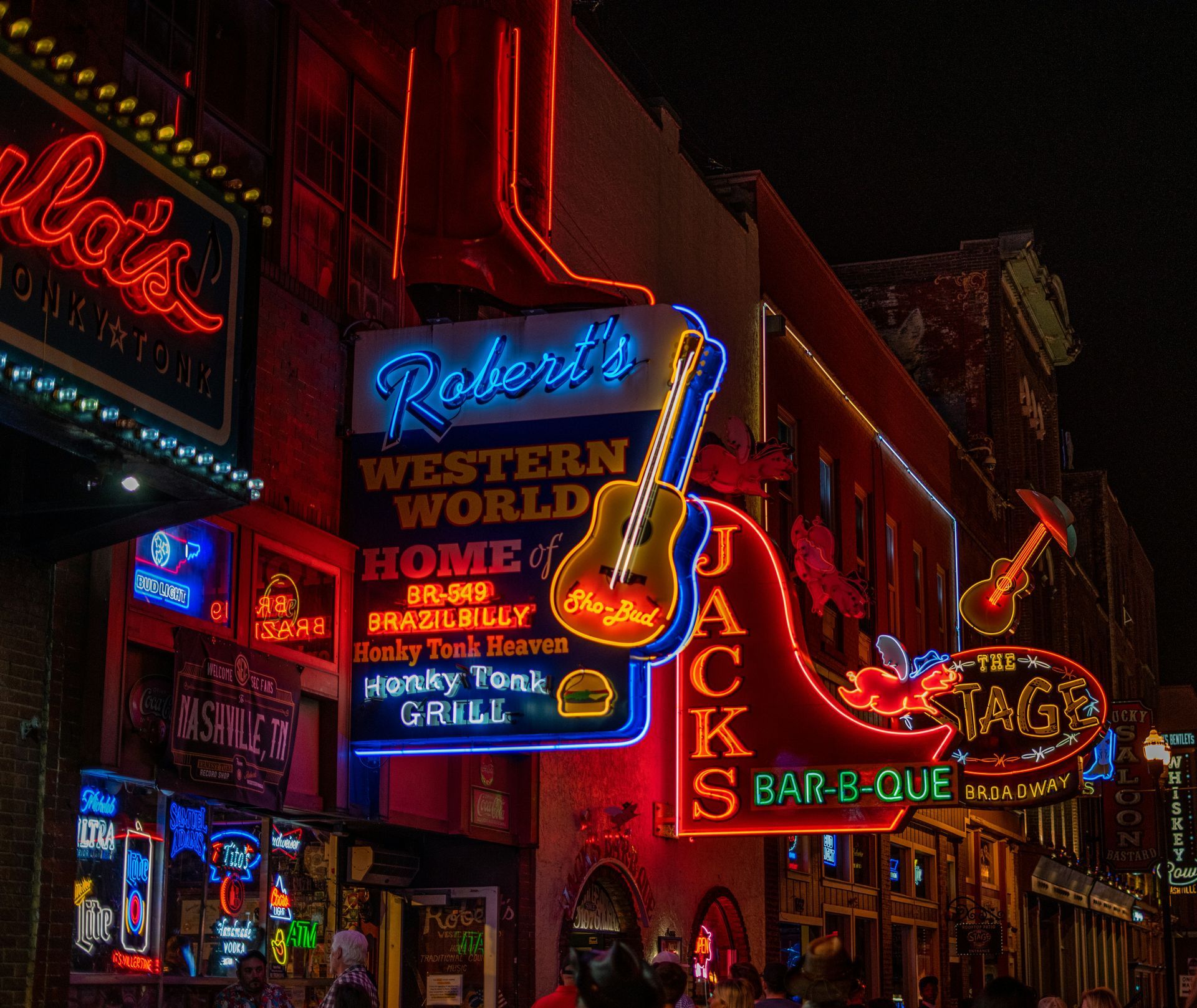 A neon sign for robert 's western world is lit up at night
