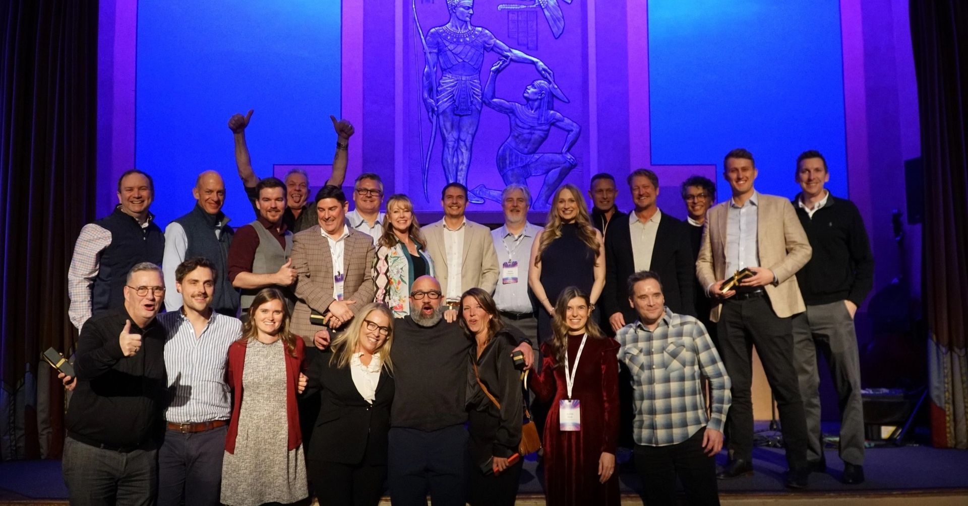 A group of people are posing for a picture on a stage.
