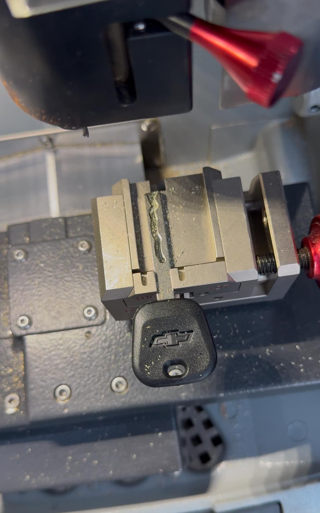 A close up of a key being cut on a machine.