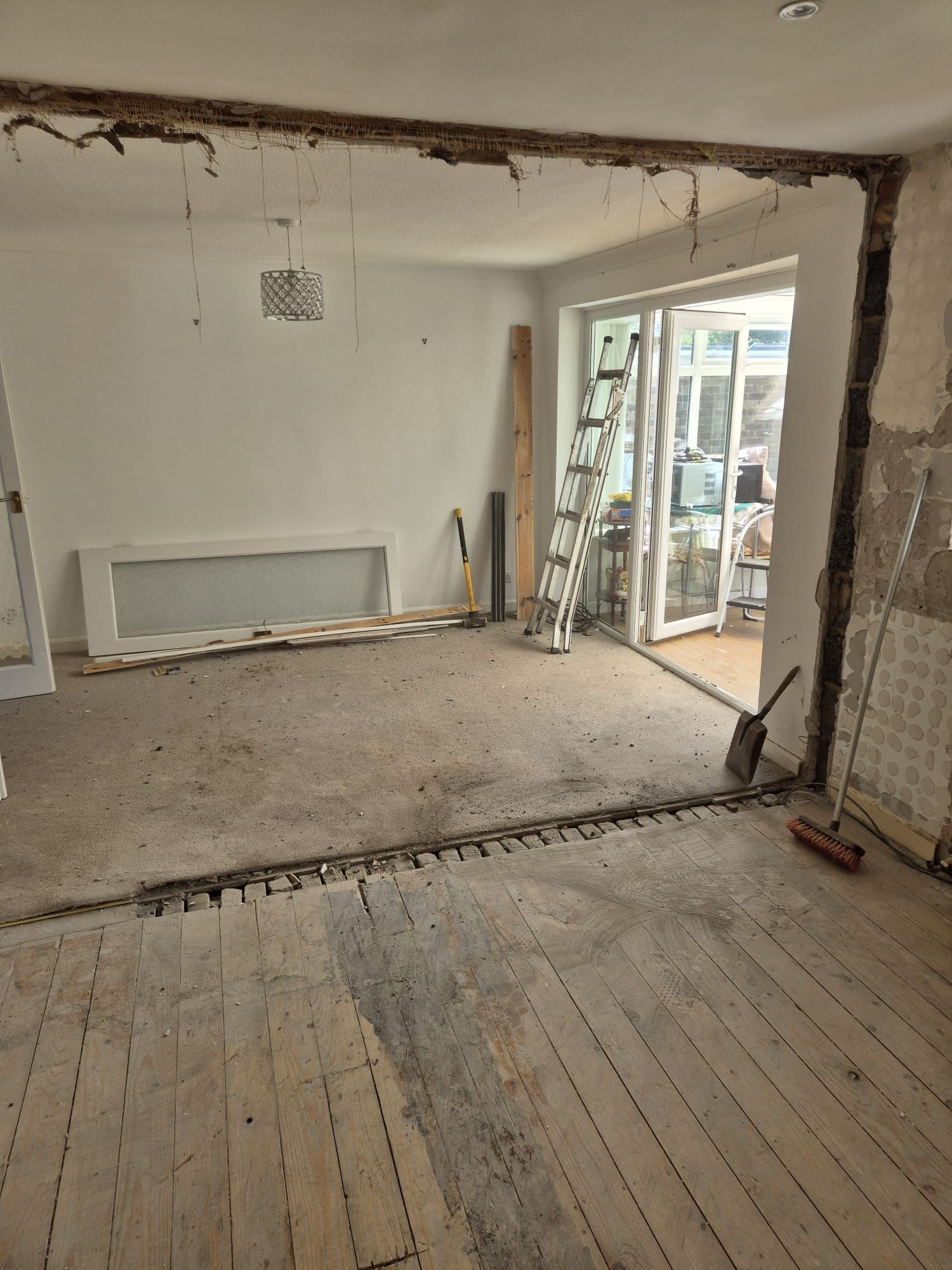 A room with a wooden floor and a ladder in it.