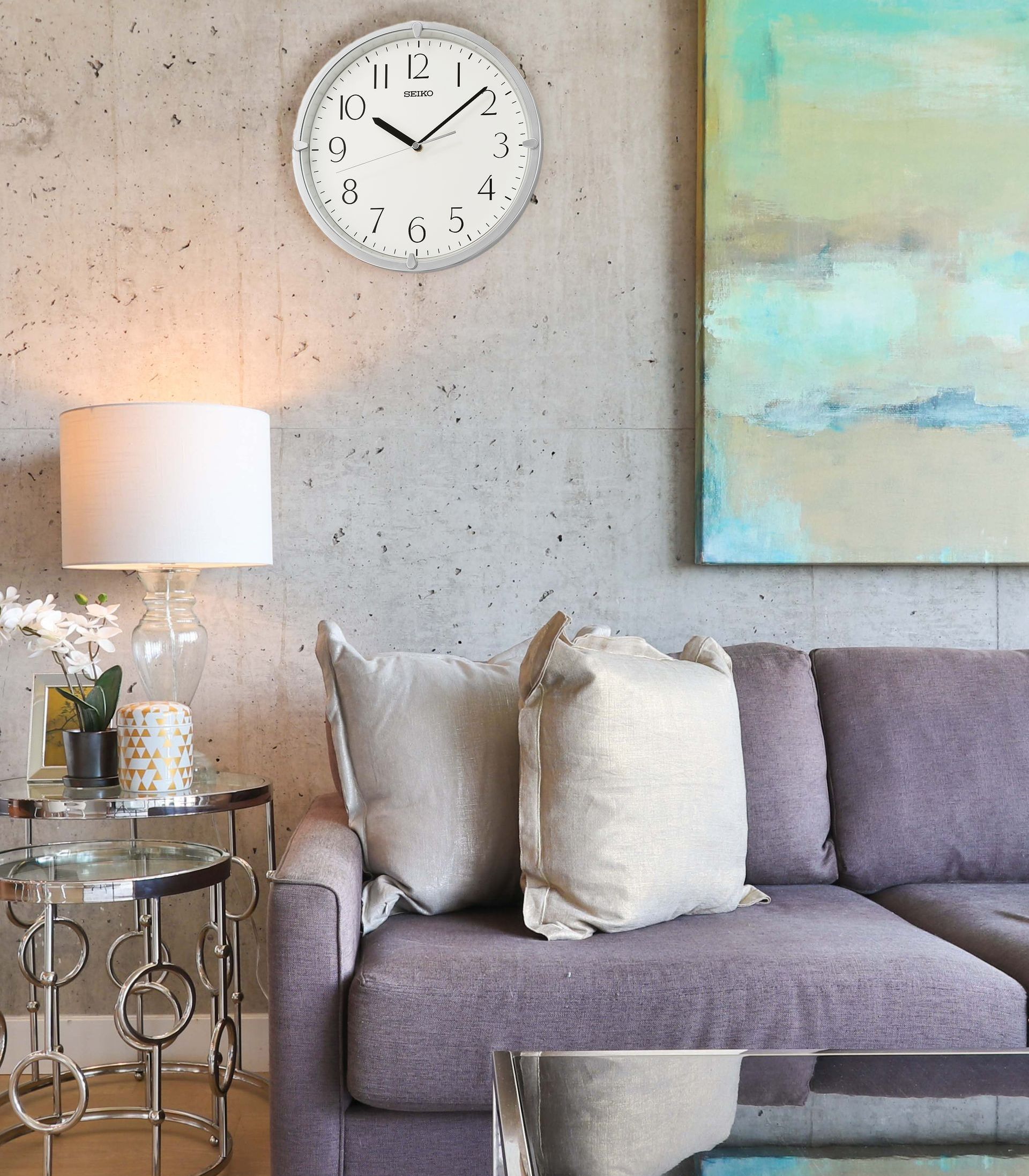 A living room with a couch and a clock on the wall