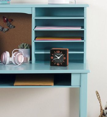 A desk with a clock and headphones on it