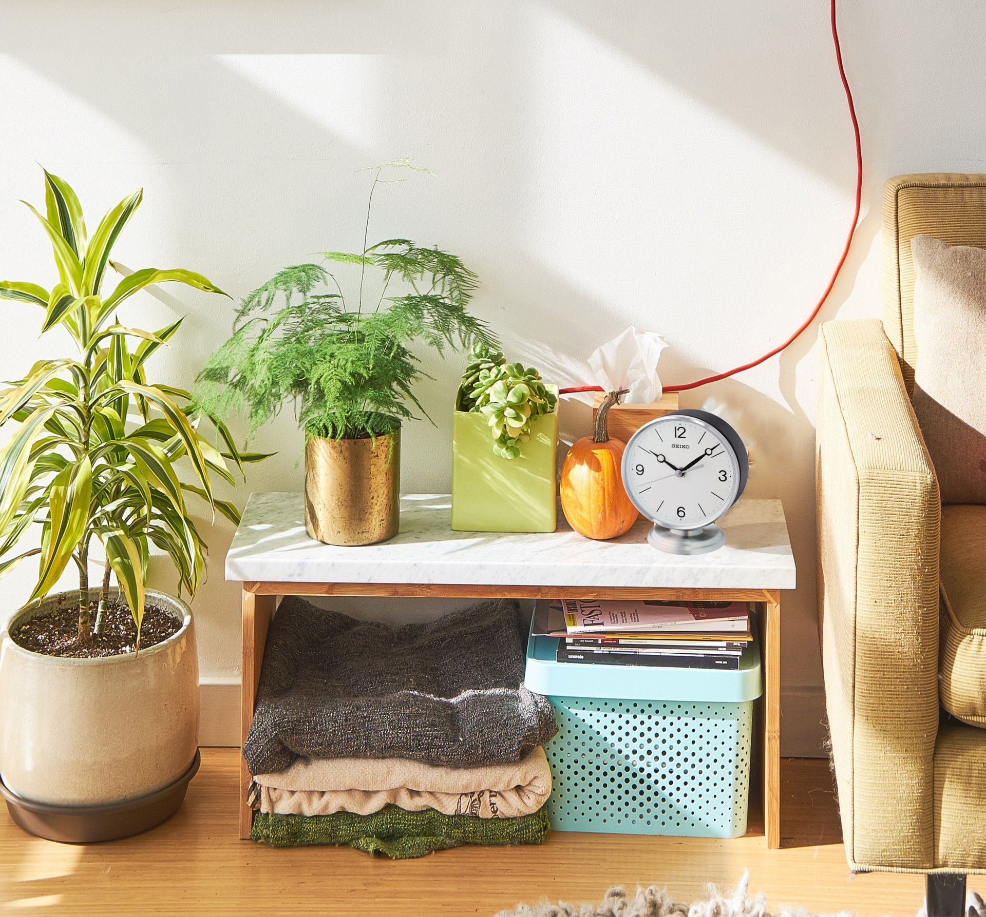A living room with a couch and a clock on a table