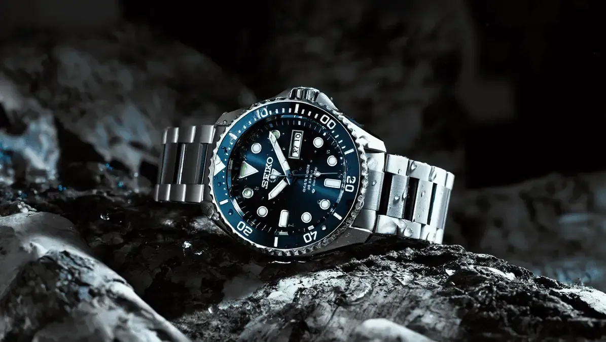 A black and white photo of a watch on a table.