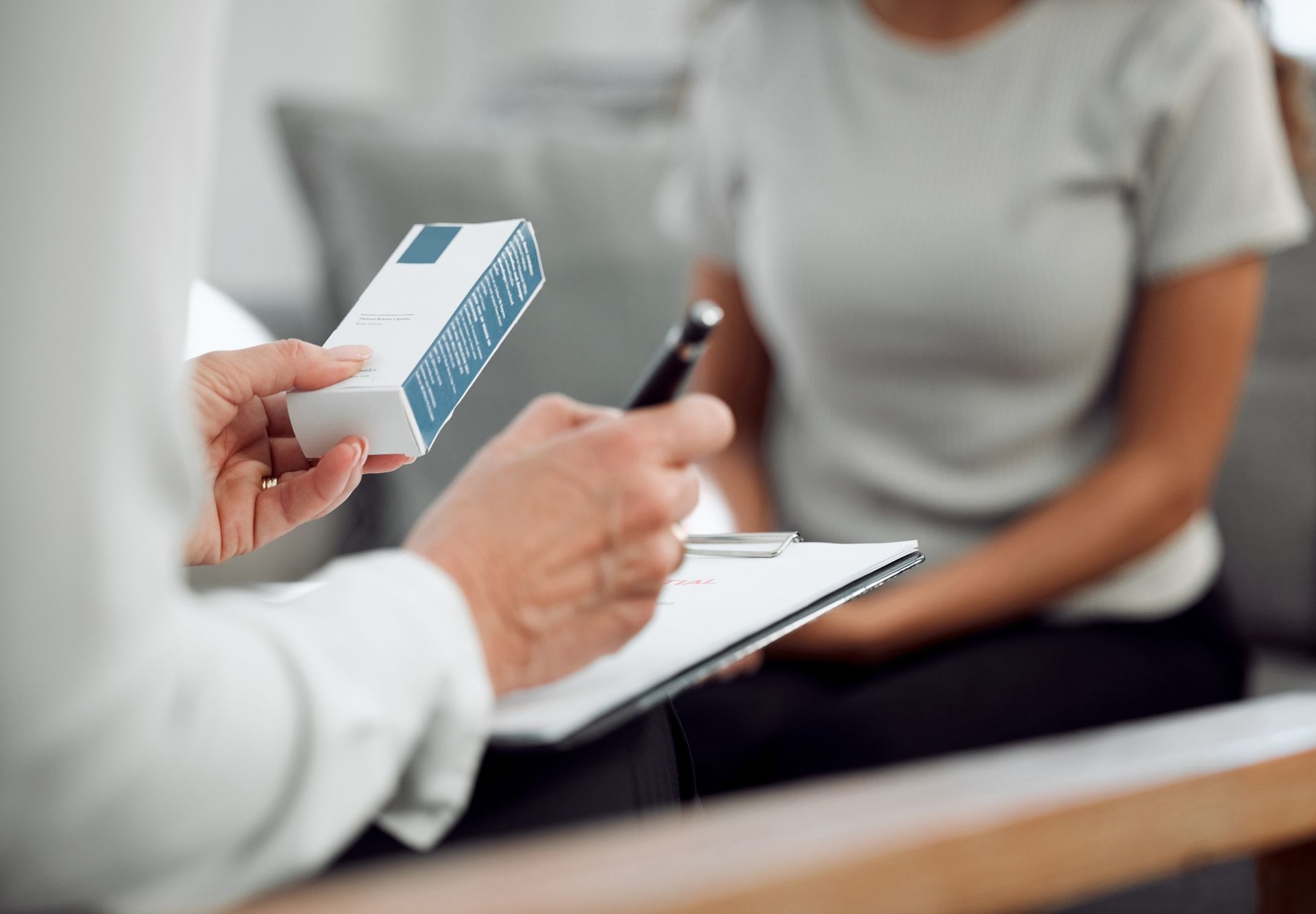 An unrecognizable specialist sitting and prescribing an addiction treatment method to a patient.