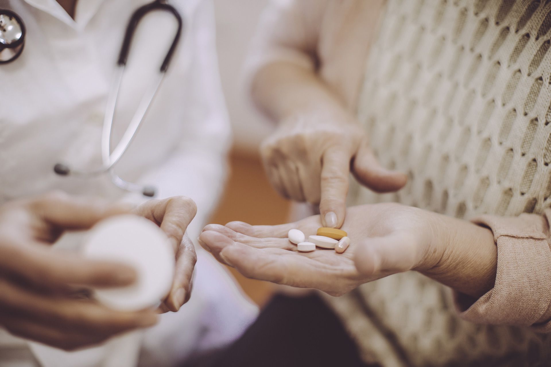 A doctor is giving a patient a handful of pills