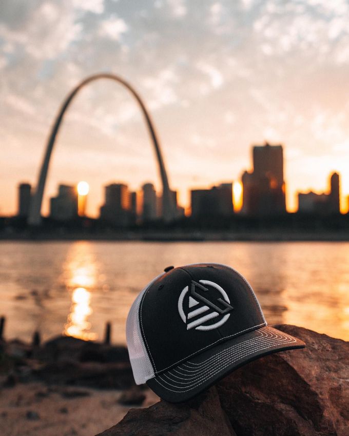 A hat is sitting on a rock in front of the st. louis arch