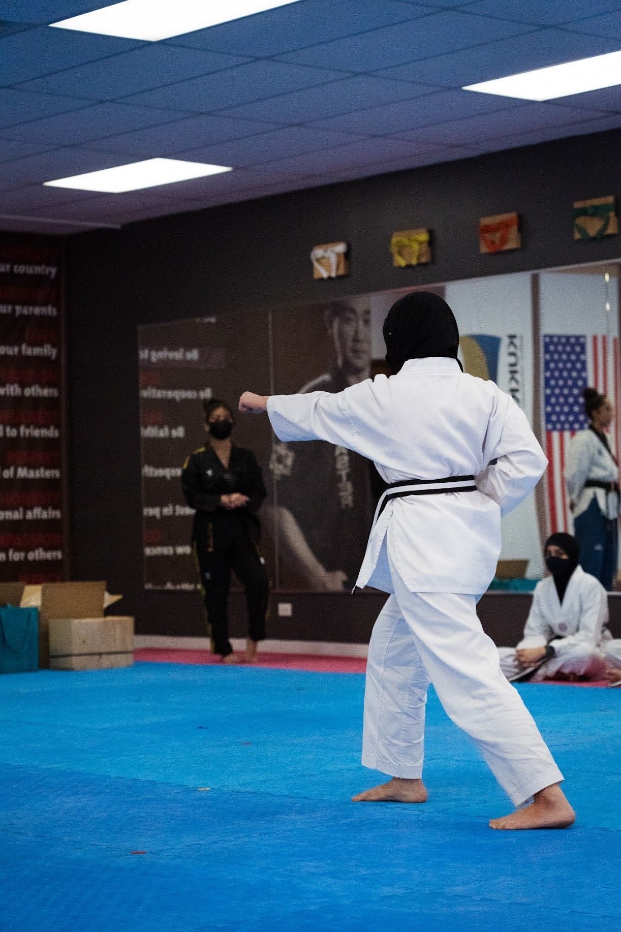 A person is practicing martial arts on a blue mat