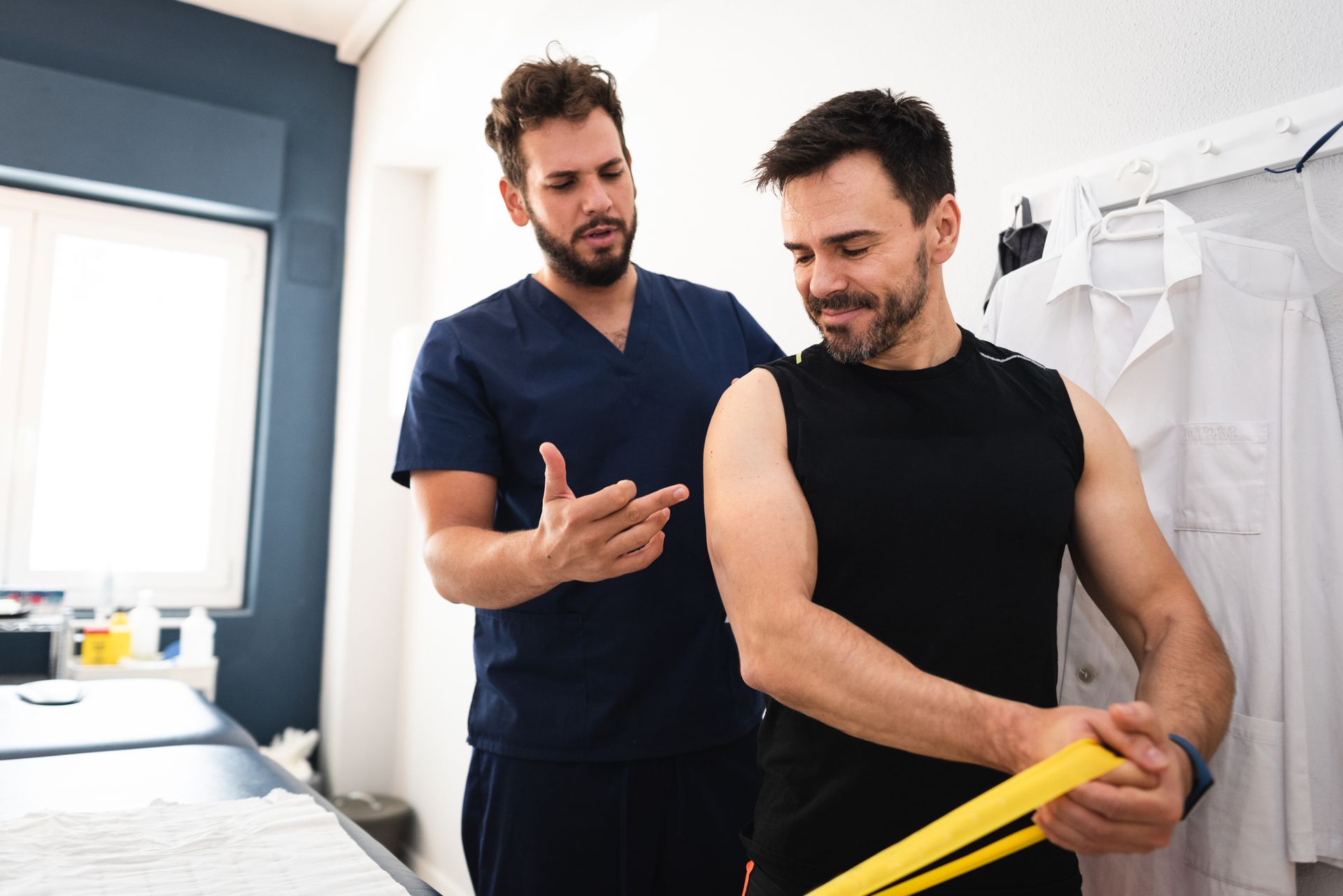 An orthopedic doctor guides a patient through resistance band exercises for recovery.