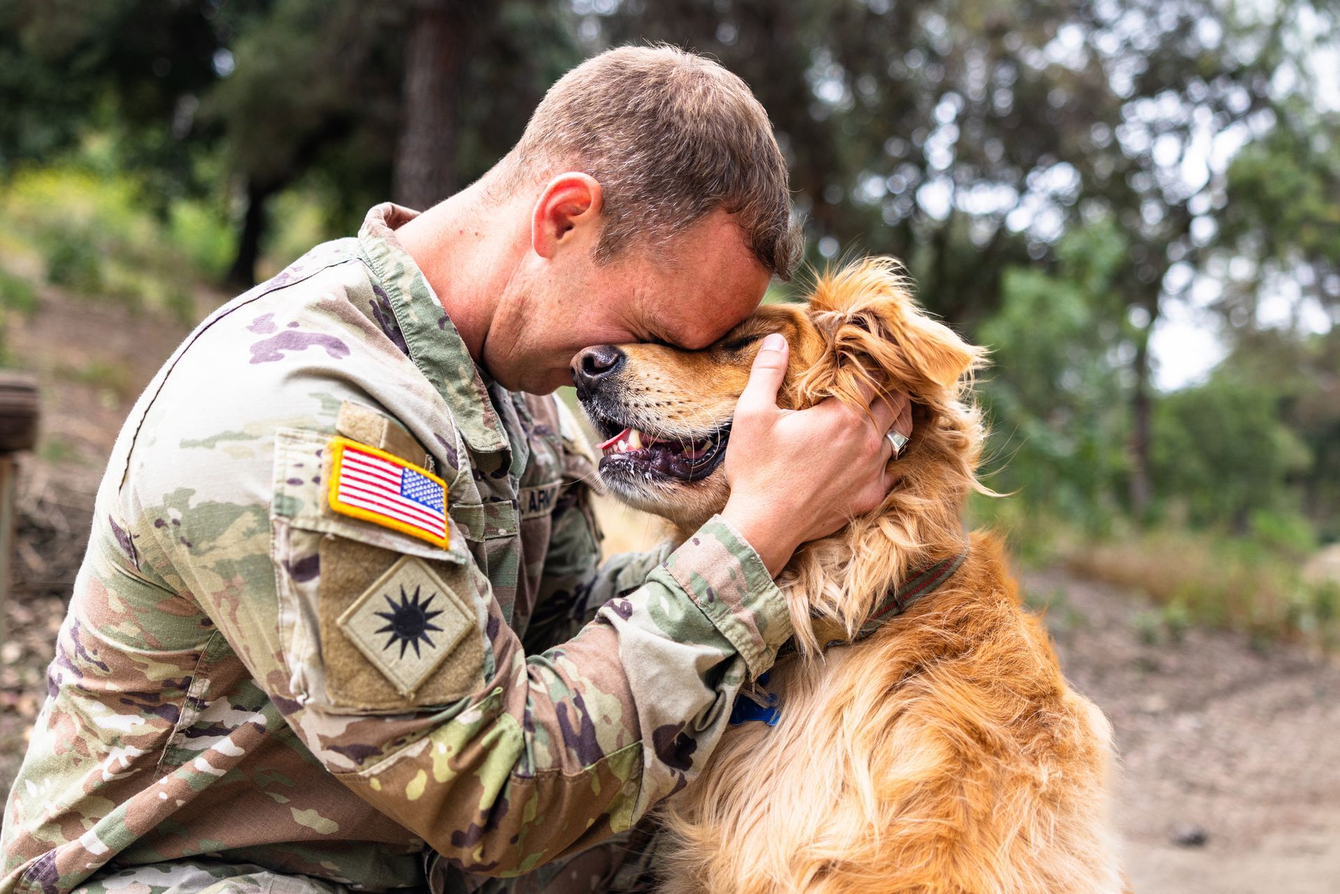 A man in a military uniform is petting a dog — DFW, TX — Texas Non-Surgical Orthopedic