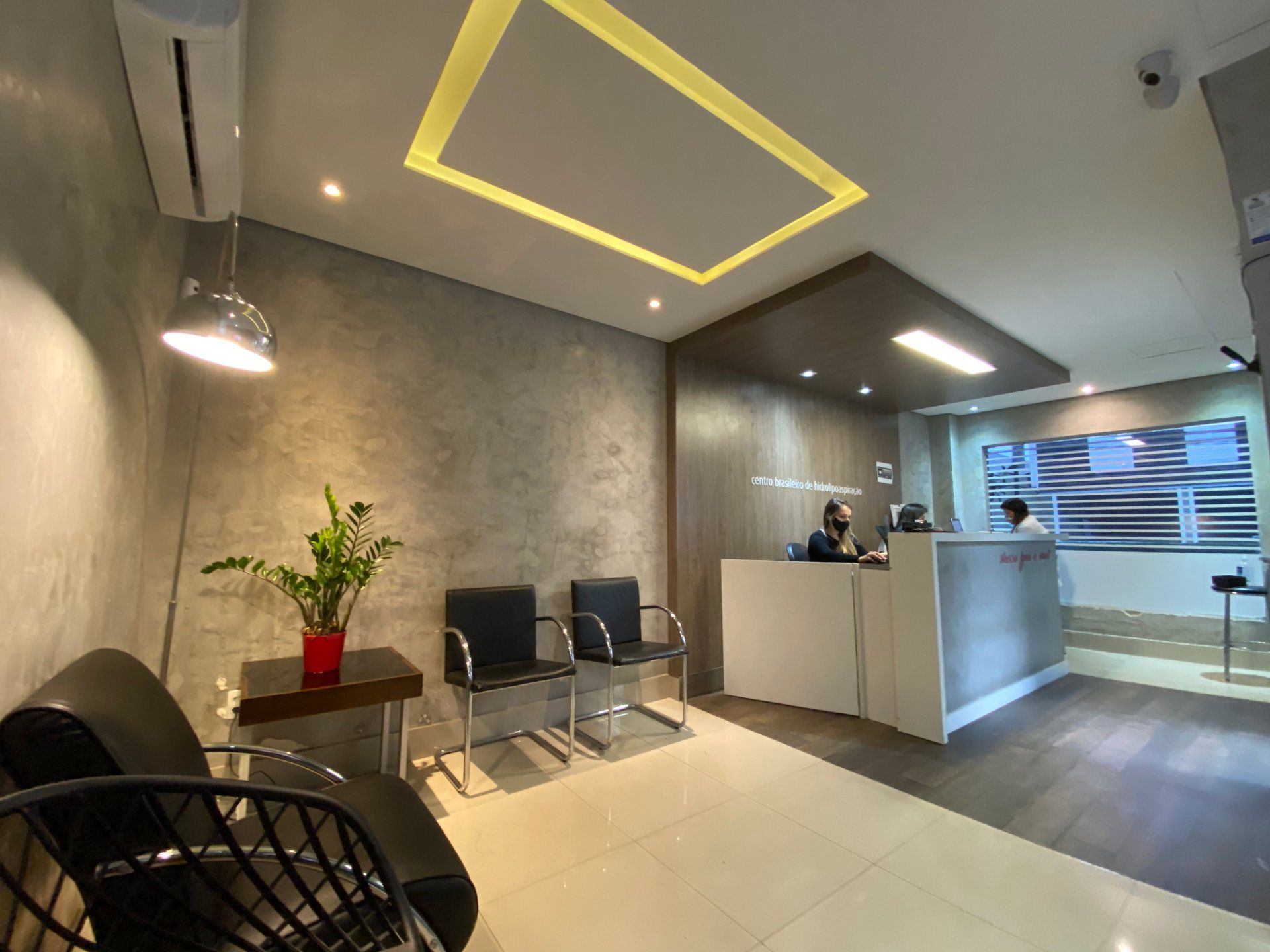 Uma sala de espera com um sofá, cadeiras e uma mesa.
